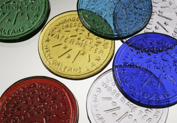 Colorful glass paperweights of New Orleans covers.