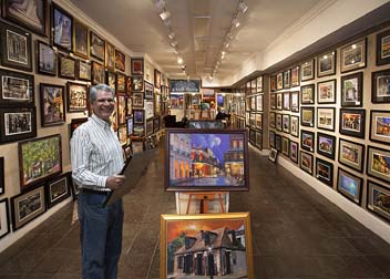 Alex Demyan surrounded by his artwork 