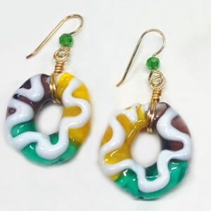 Purple, Green and Yellow glass earrings shaped like a Mardi Gras King Cake with white icing on top