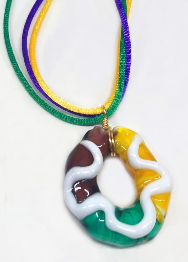 Purple, Green and Yellow Glass pendant in shape of a Mardi Gras King Cake with white paint for icing on top.