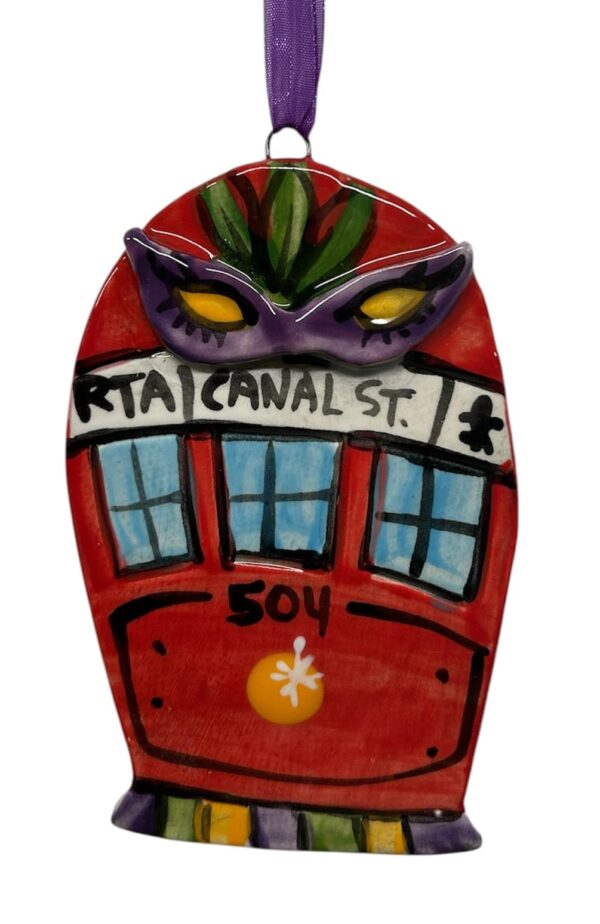Red streetcar decorated with a Mardi Gras mask ceramic ornament hand painted by Katie Baldwin